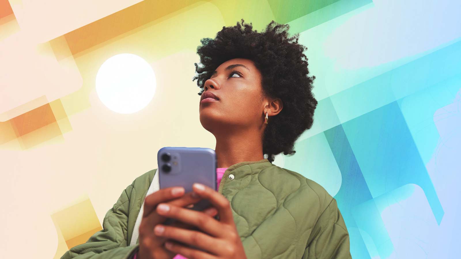 Mulher segura o celular e desvia o olhar da tela diante de um fundo colorido