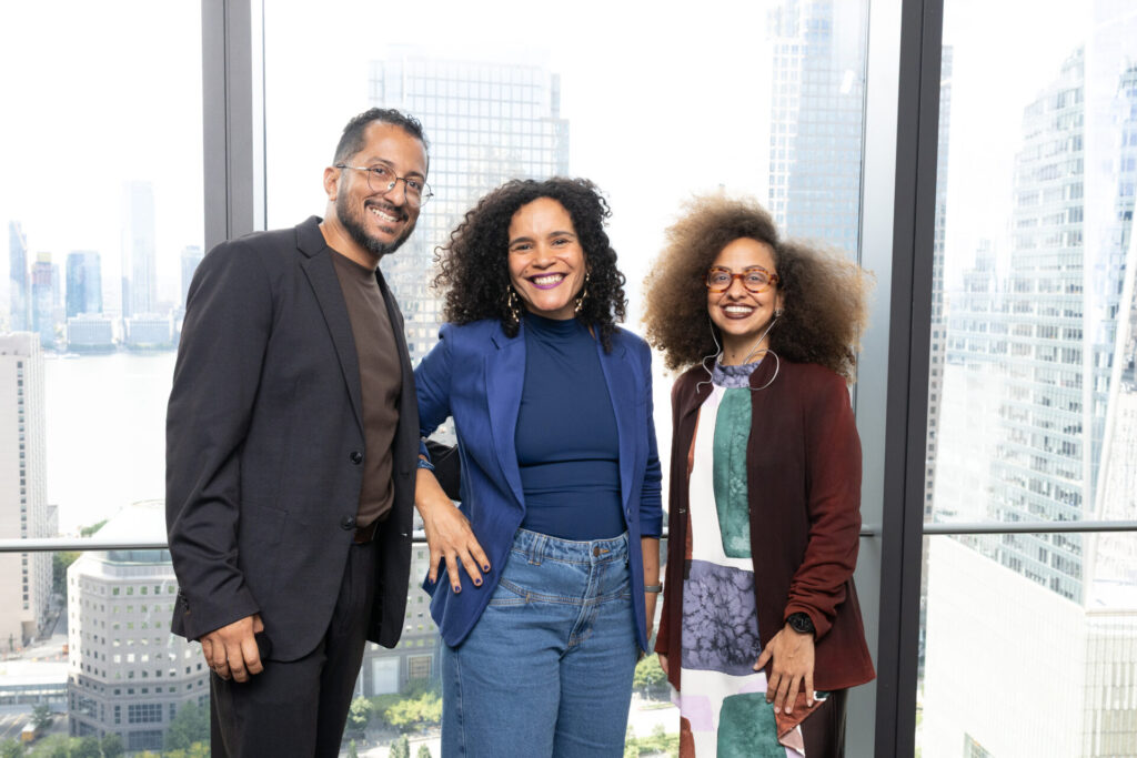 Eliezer Leal, Talita Matos e Carolina Spotorno, fundadores da AZO, posam diante da paisagem de Nova York.