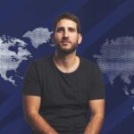 Guilherme Stefanini diante de um mapa-múndi que destaca a América do Norte e a região Ásia-Pacífico.