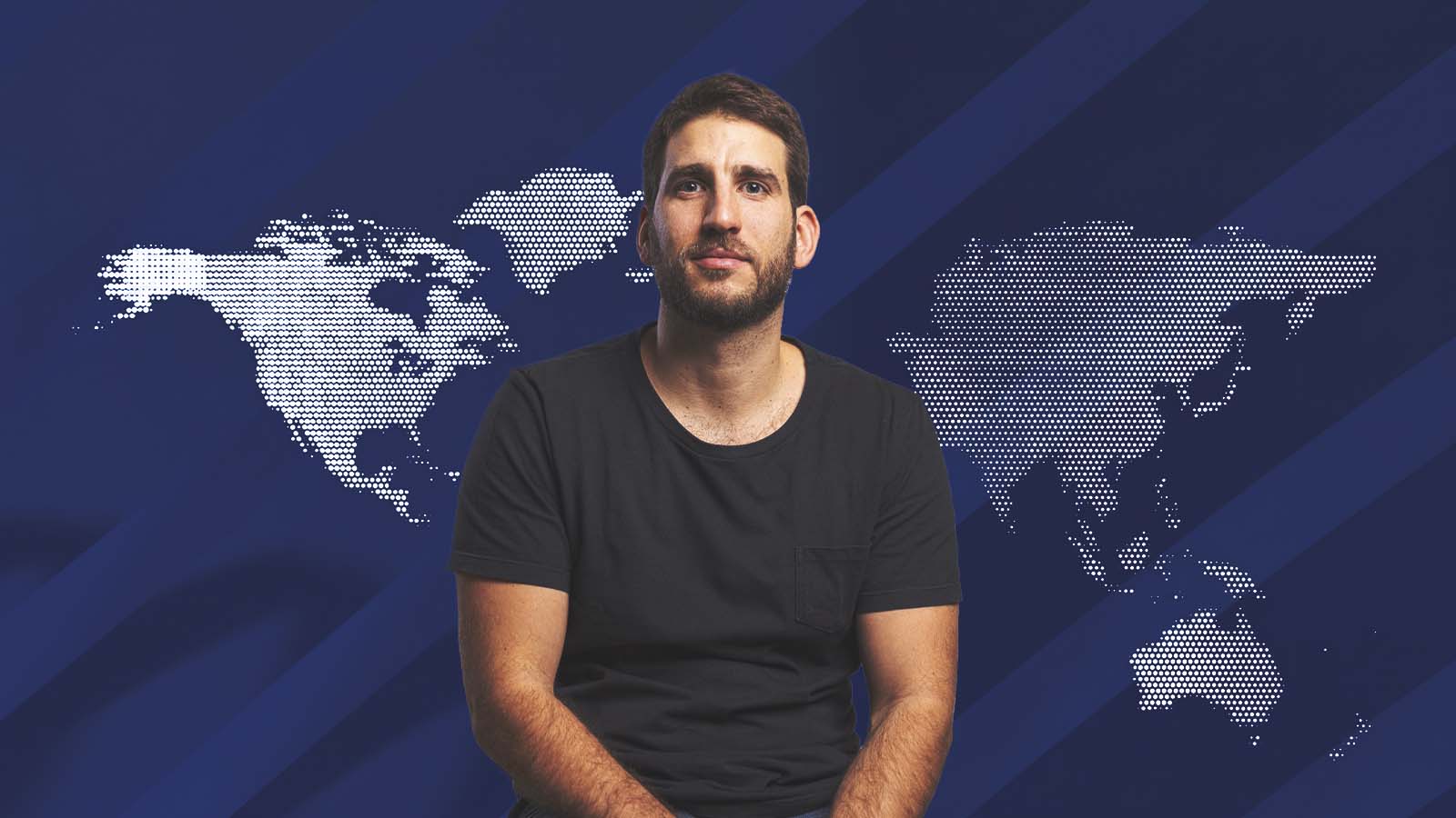 Guilherme Stefanini diante de um mapa-múndi que destaca a América do Norte e a região Ásia-Pacífico.