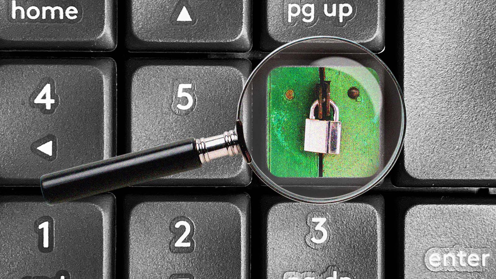 Lupa destaca um cadeado sobre o teclado de um computador