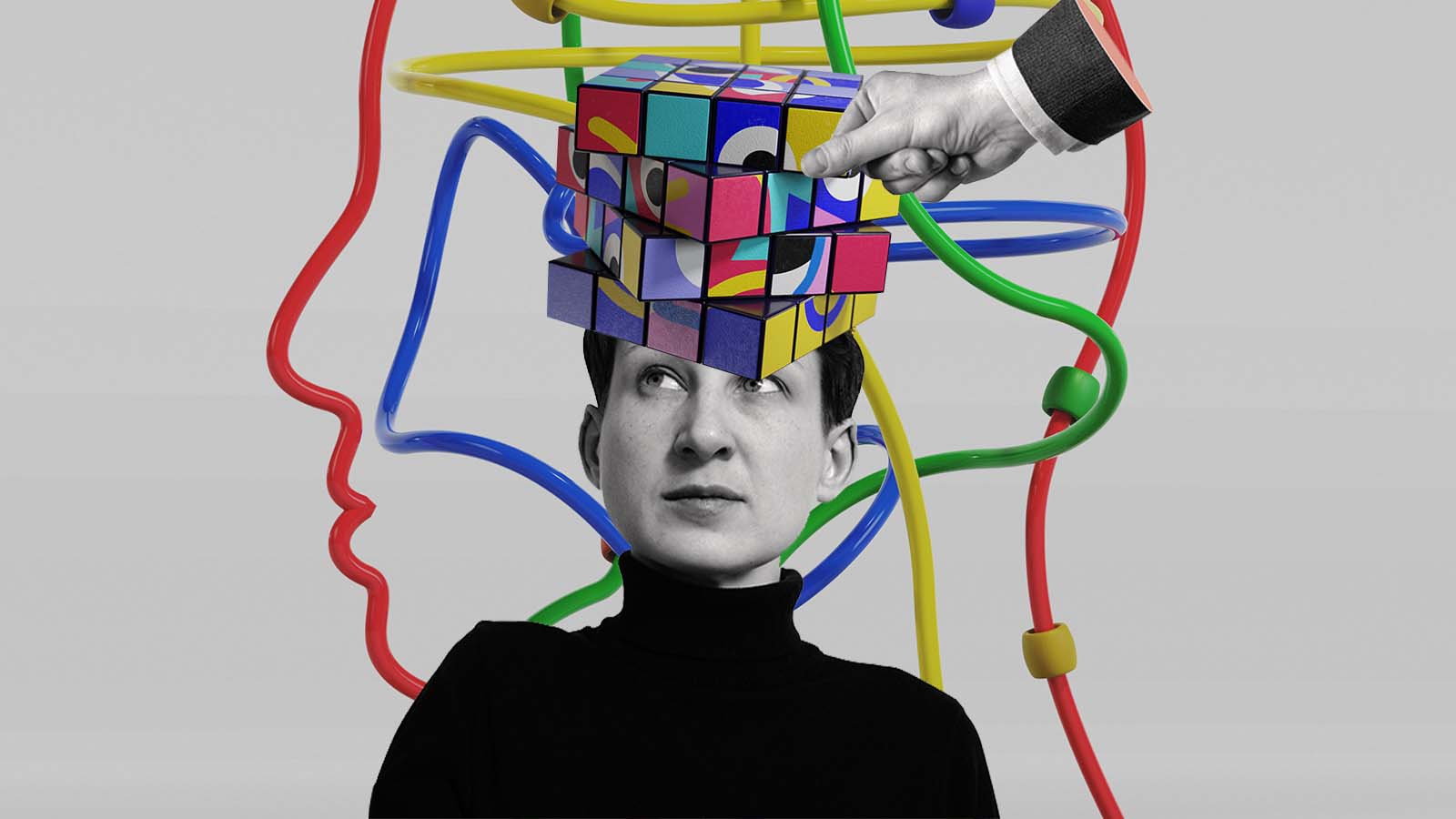 Pessoa com um cubo colorido sobre a cabeça enquanto uma mão reorganiza uma das peças