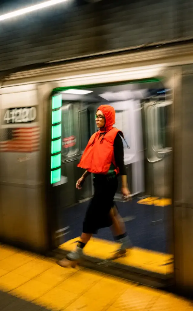 Passageira usa o colete vermelho Lifeline ao desembarcar de um trem do metr&ocirc; de Nova York.