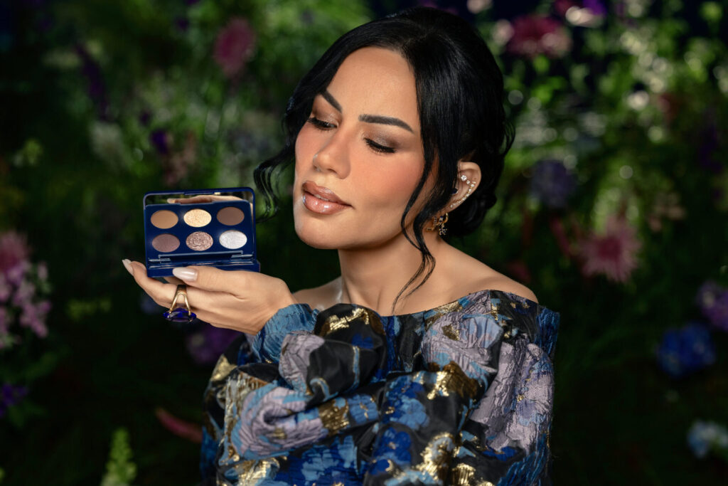 Imagem de divulgação da coleção Bruna Tavares × Bridgerton. Uma modelo apresenta um produto labial com embalagem inspirada na série da Netflix.