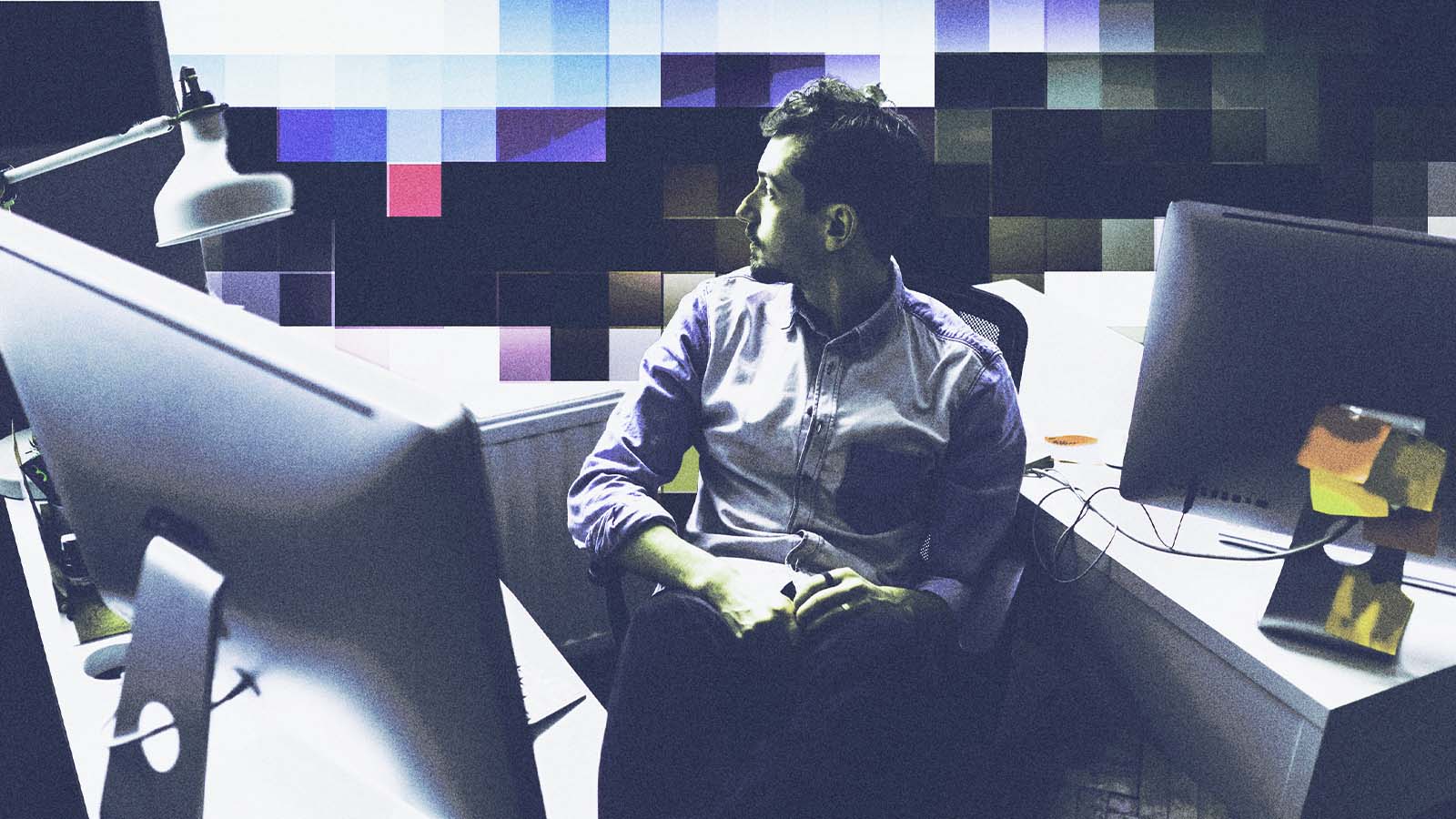 Homem em escritório diante de computadores, com efeito de mosaico digital na imagem.