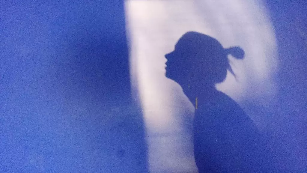 mulher solit&aacute;ria olha para uma parede