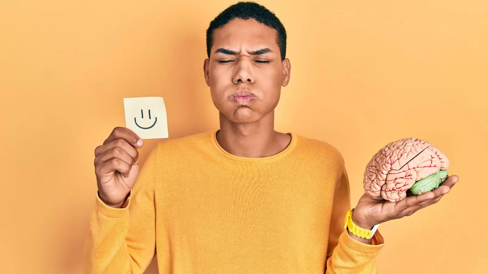 Homem negro segurando um cerébro e uma folha com rosto feliz