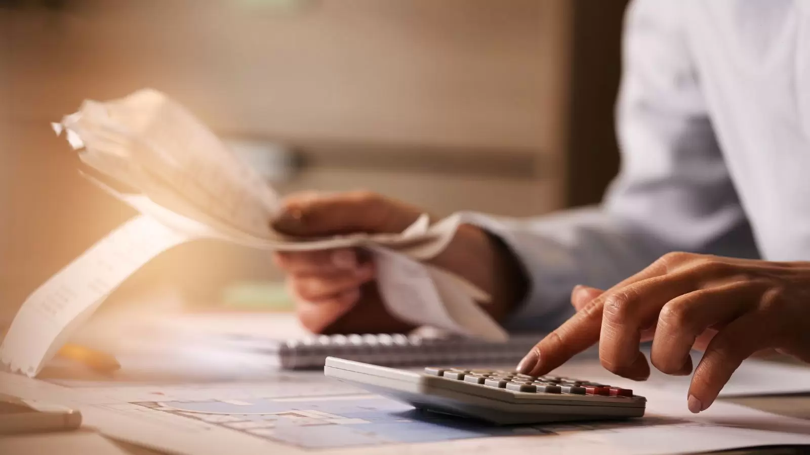 Homem usando calculadora ao passar por contas e impostos no escritório