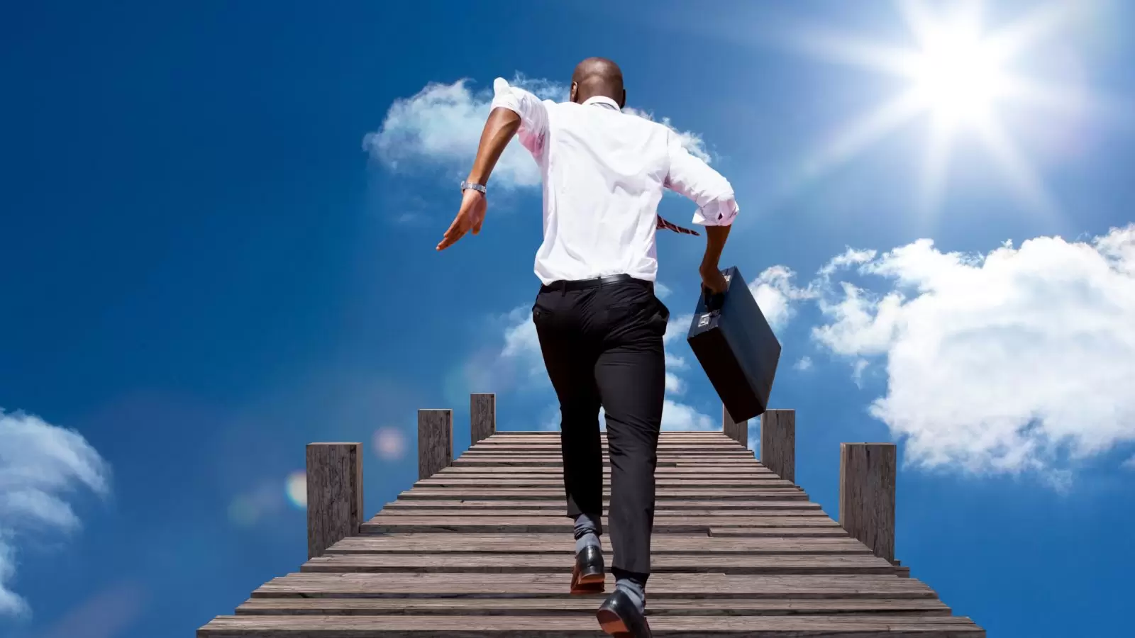 Homem subindo escada em direção ao céu