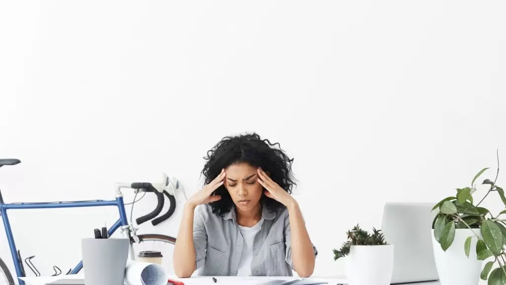 Mulher negra estressada no trabalho