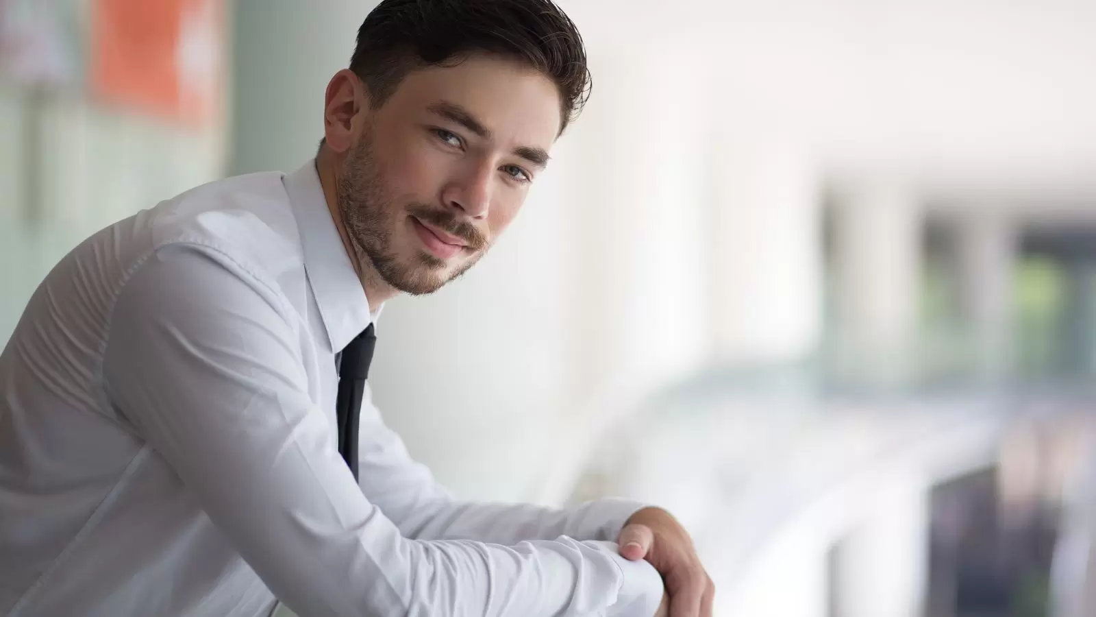 Gerente masculino bem sucedido apoiado em trilhos