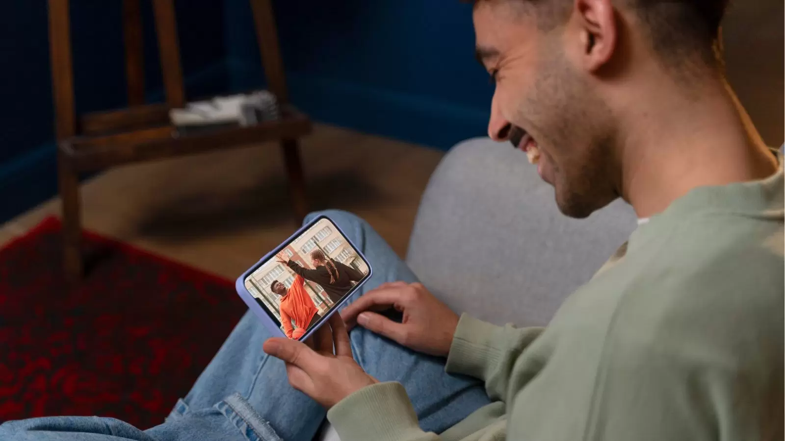 Jovem assistindo vídeo pelo celular