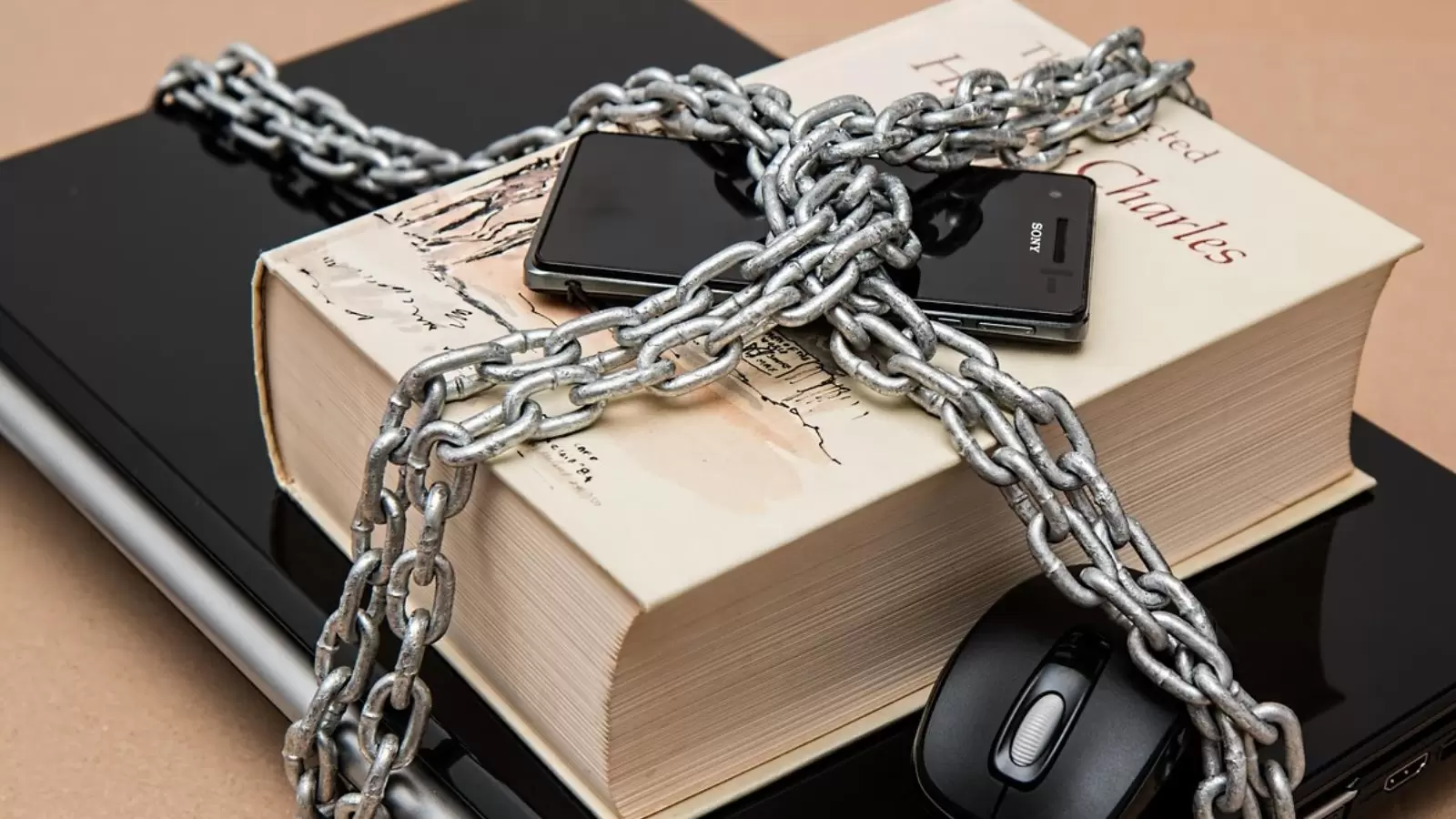 Celular acorrentado em cima de livro