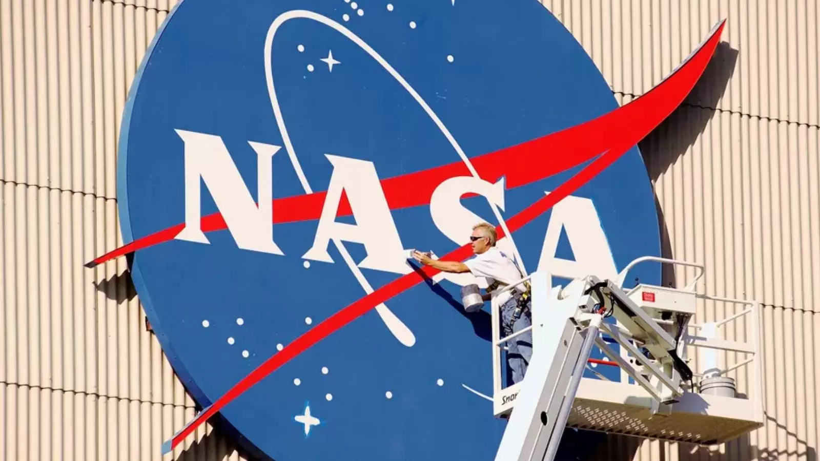 Símbolo da Nasa e homem pintando ele