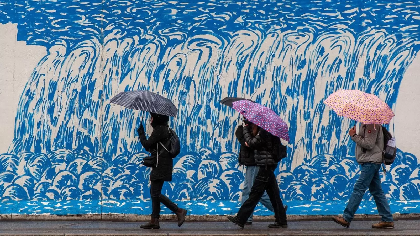Pessoas indo trabalhar com guarda-chuva