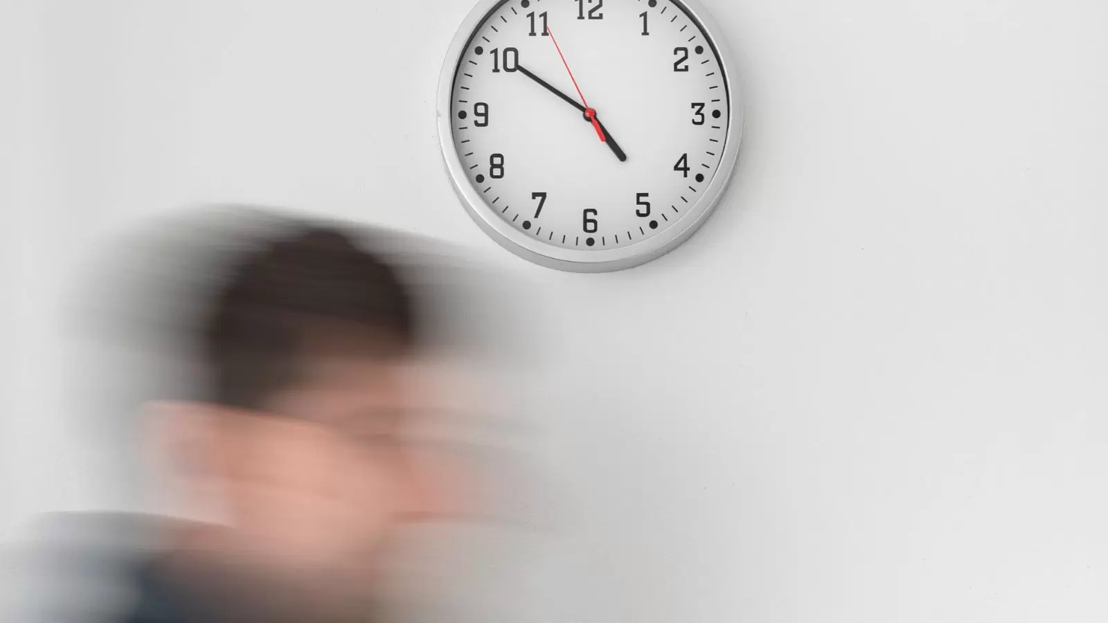 Homem correndo e relógio ao fundo