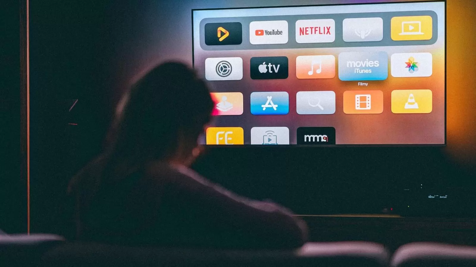 Mulher escolhendo streaming na TV