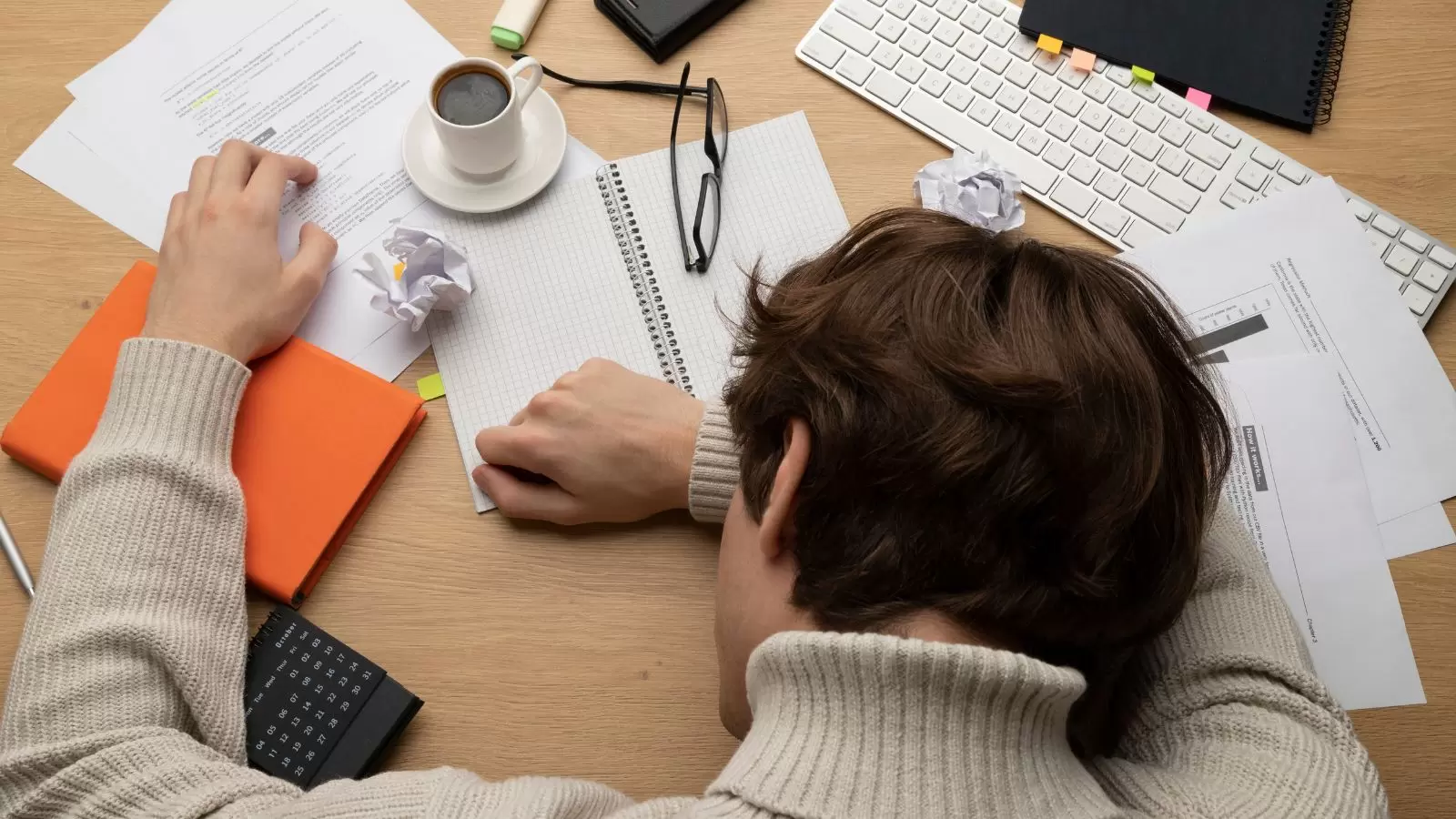 Mulher deitada na mesa com papeis espalhados
