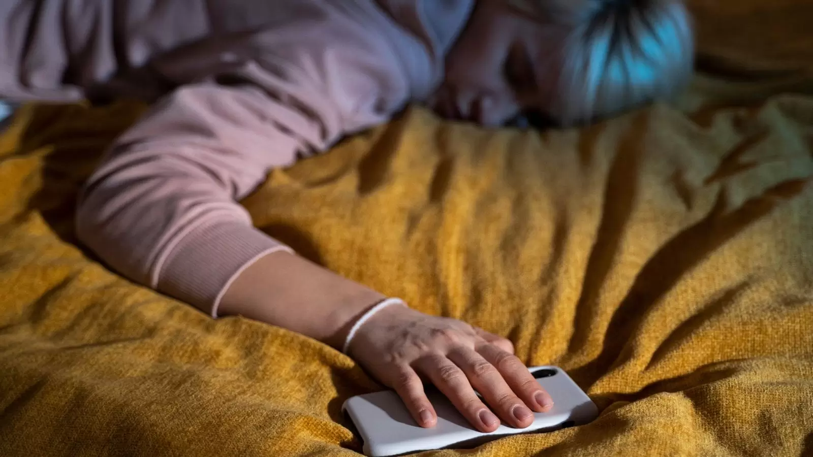 Mulher dormindo com celular na mão