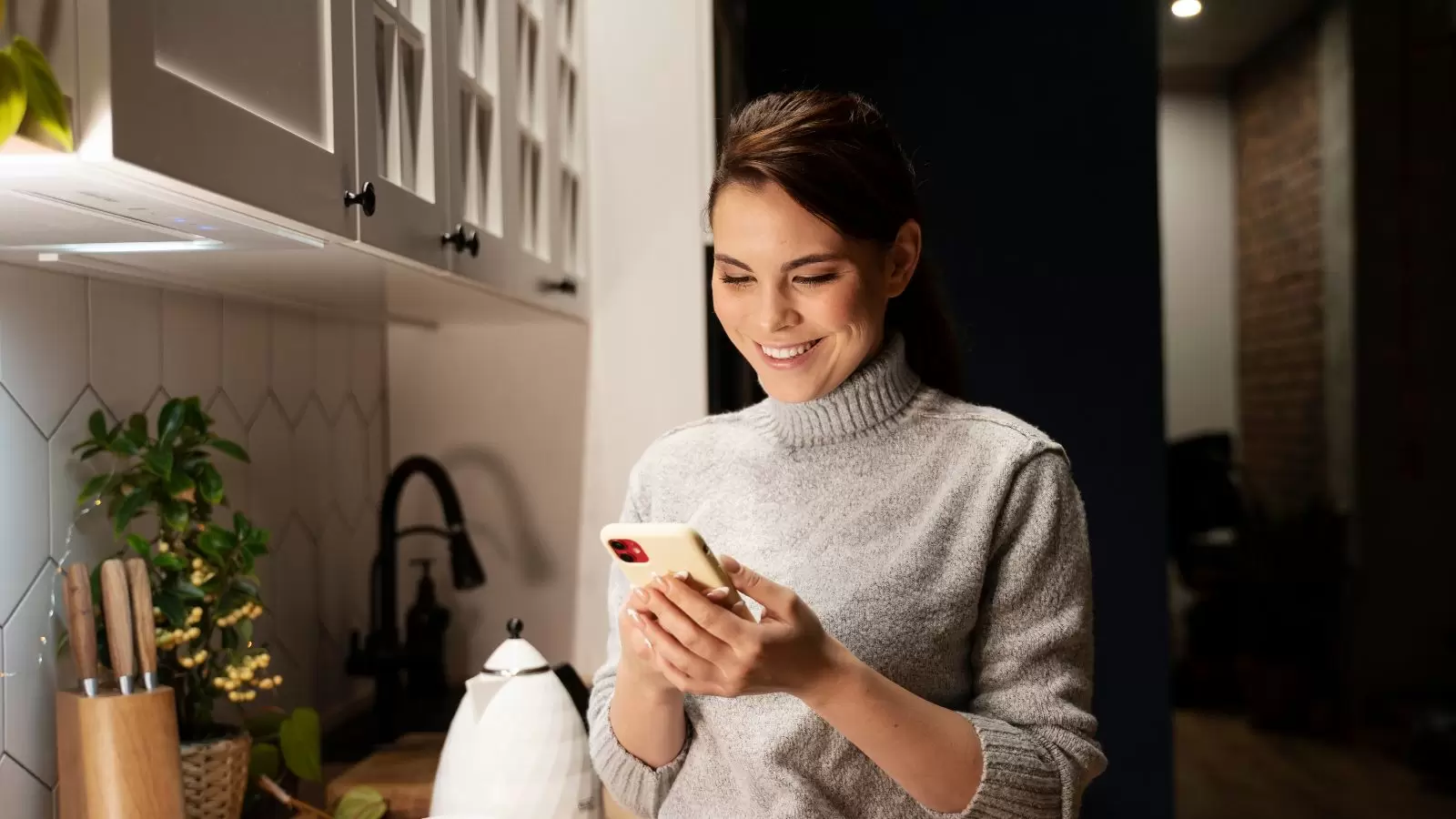 Mulher mexendo no celular em casa