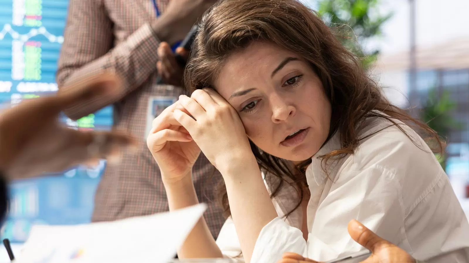 Mulher com semblante triste acompanhando reunião