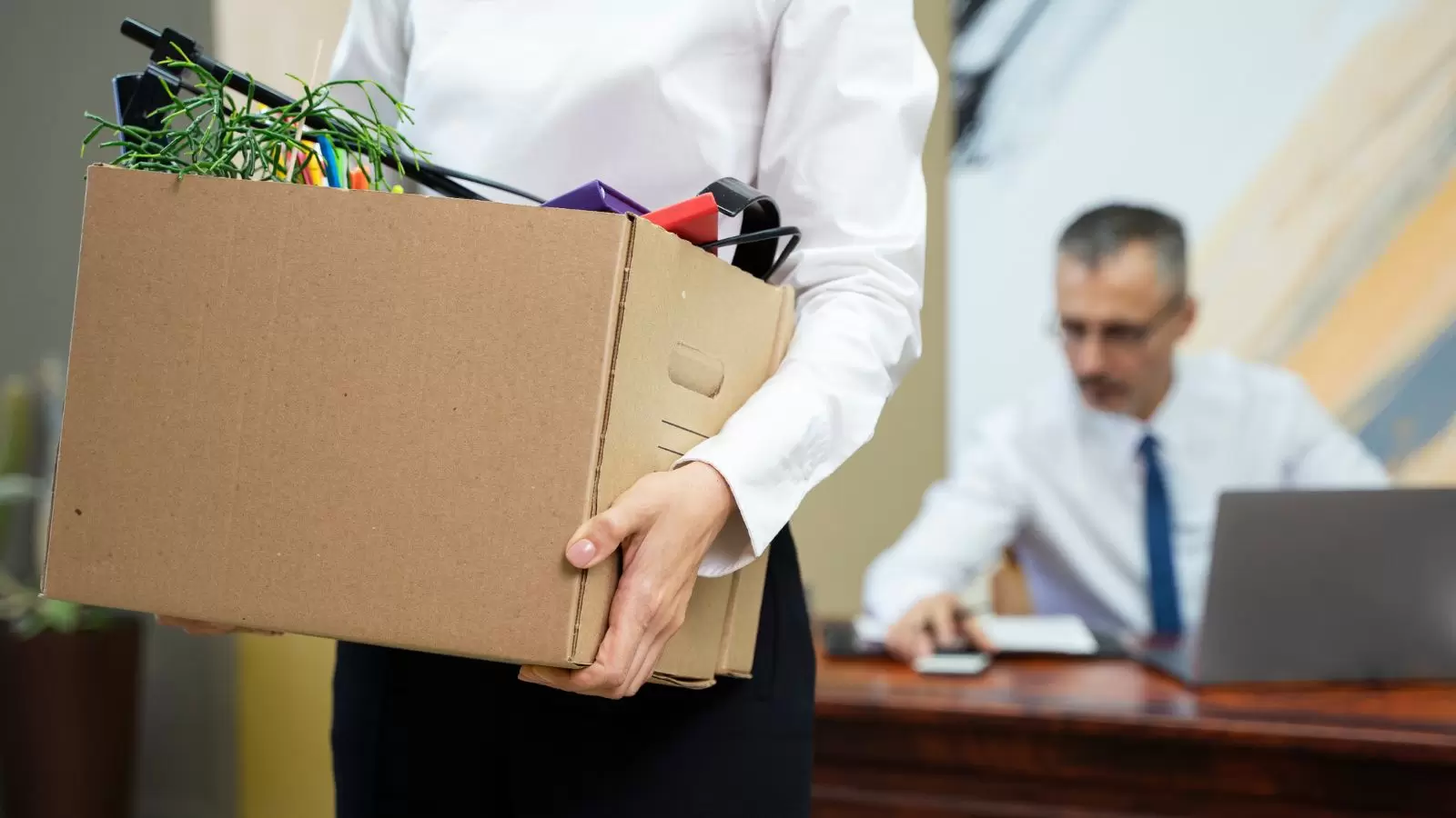 Homem carregando caixa após demissão