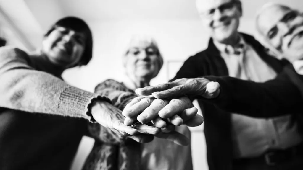 Idosos juntando as m&atilde;os em preto branco