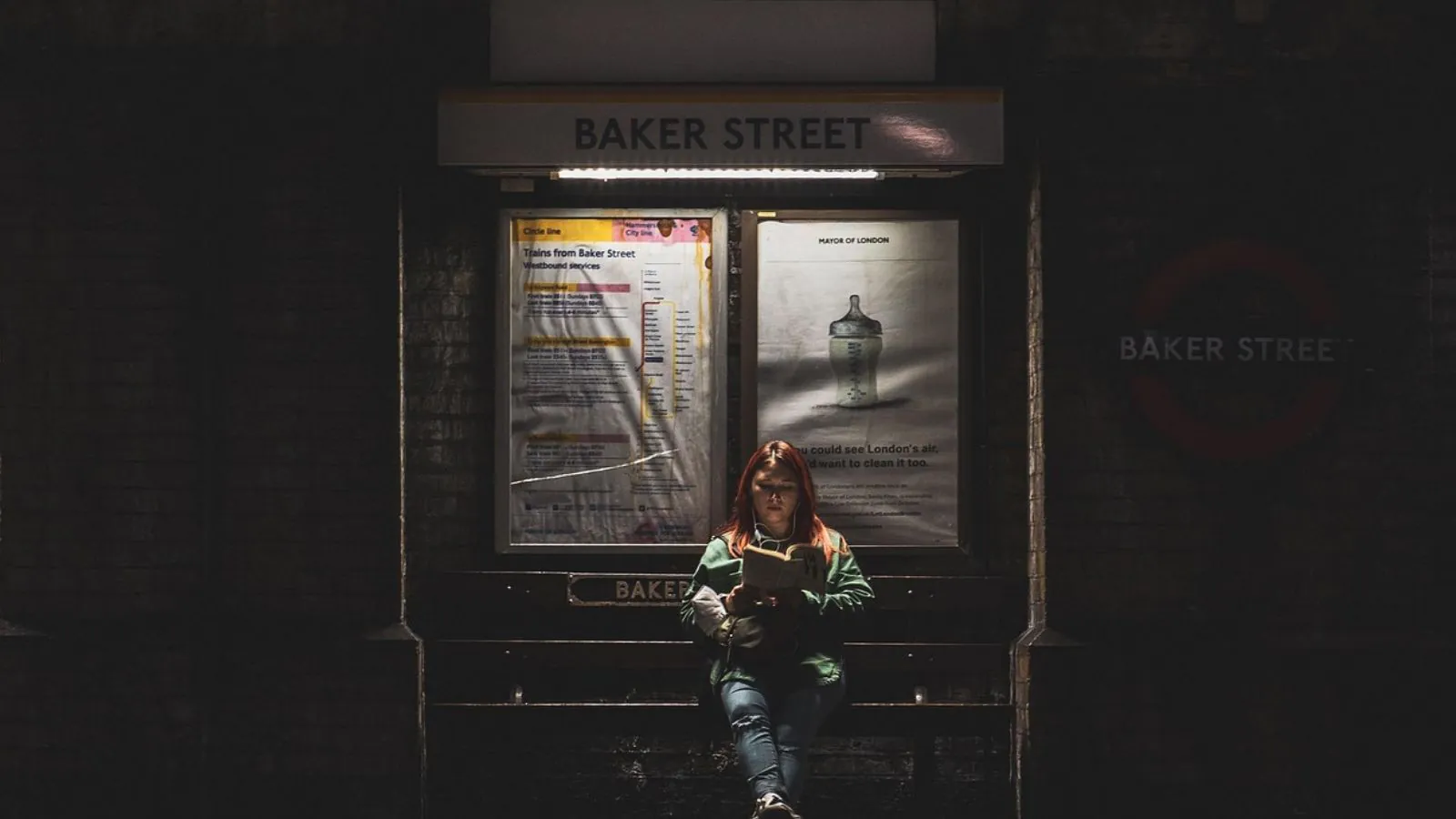 Mulher lendo livro em parada de ônibus