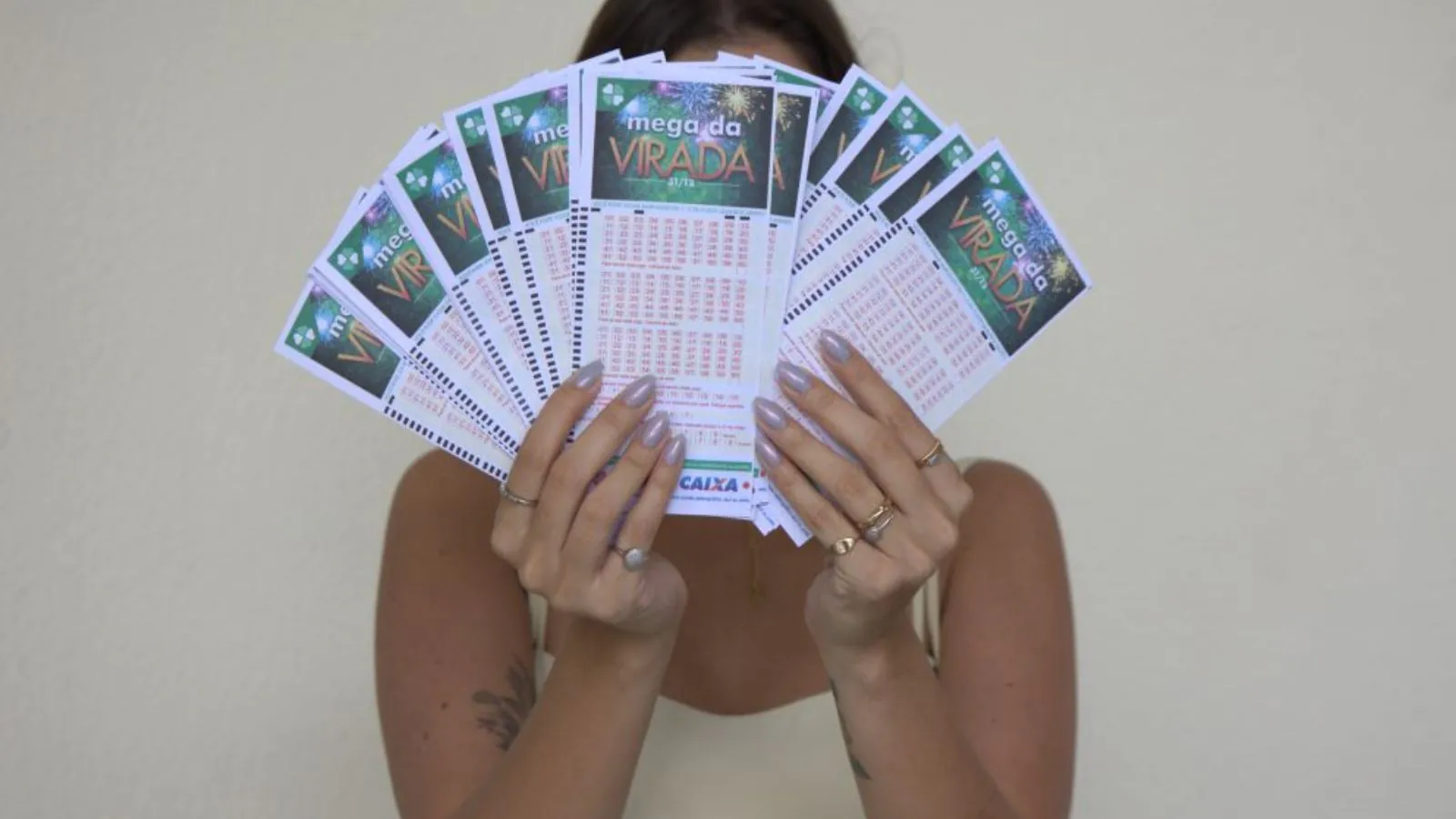 Mulher segurando bilhetes da Mega