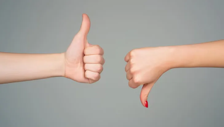 mãos fazendo sinal de positivo e negativo