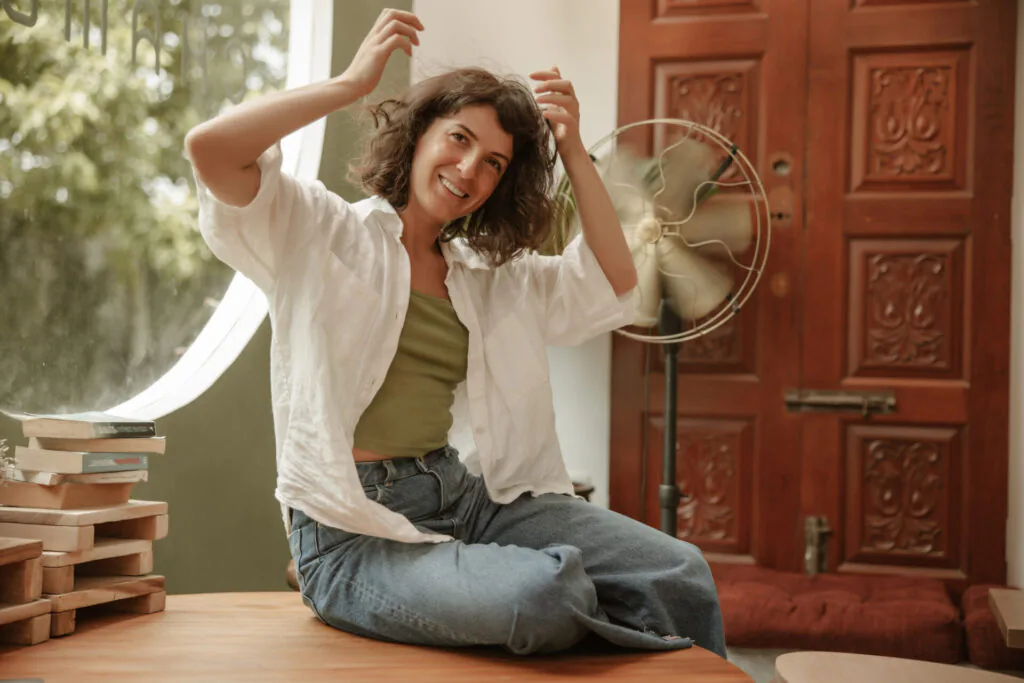 Mulher em casa com ventilador