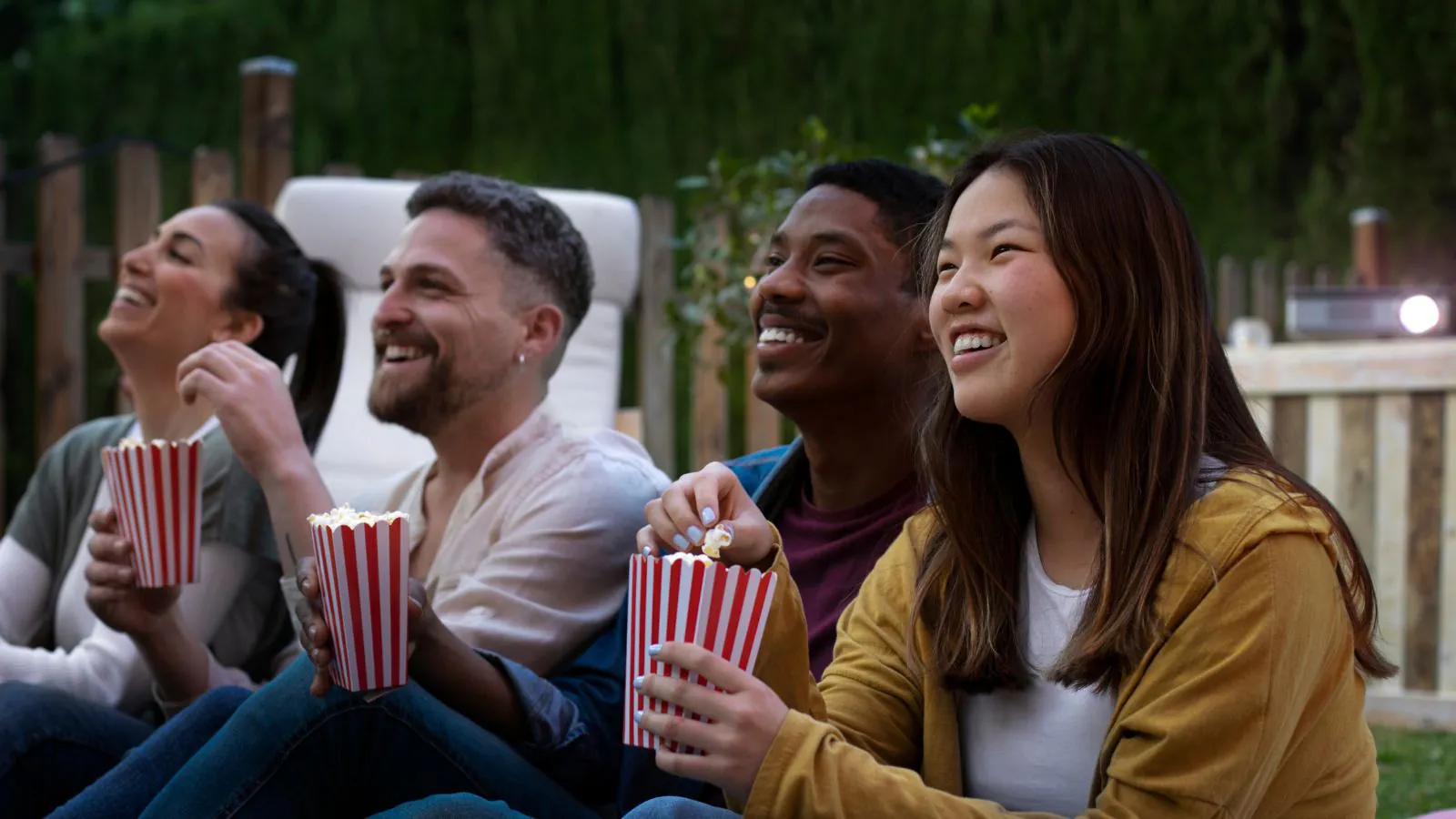 Amigos assistindo filmes no quintal