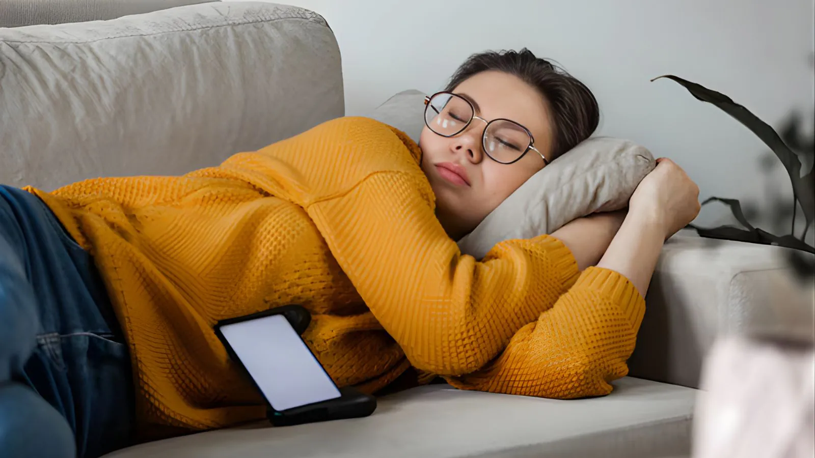 Mulher asiática tirando um cochilo no sofá.