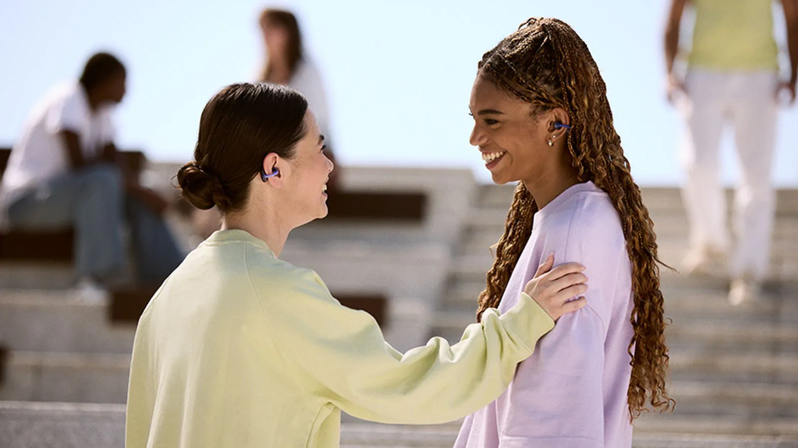 Duas meninas conversando com o novo fone JBL no ouvido