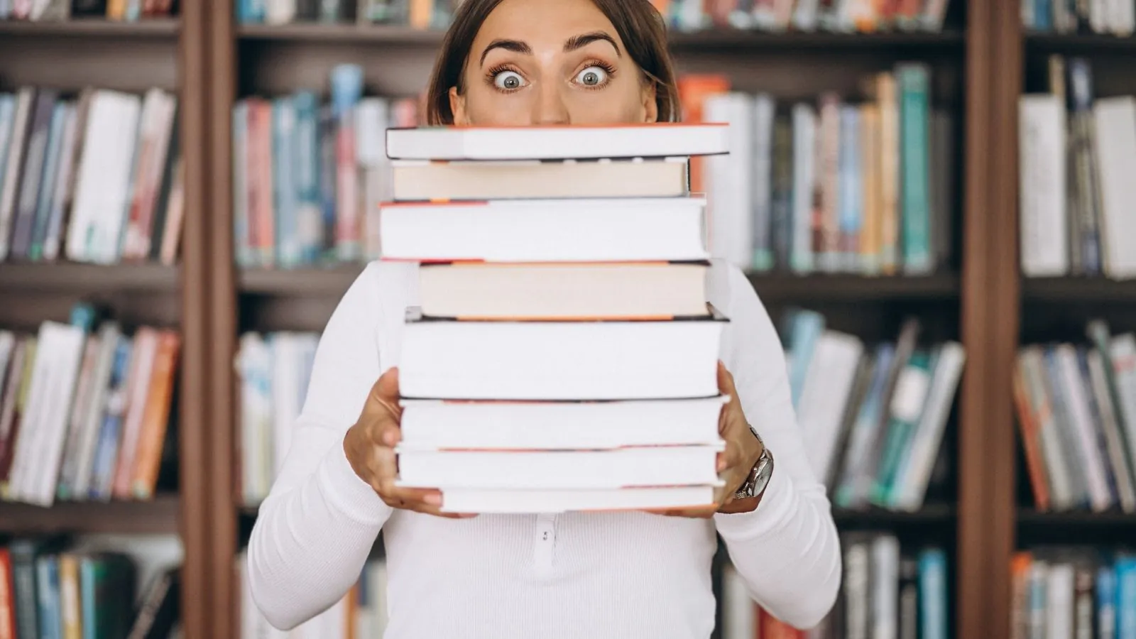 Mulher segurando pilha de livros