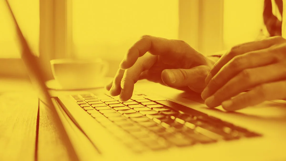 Mão de homem usando o notebook.