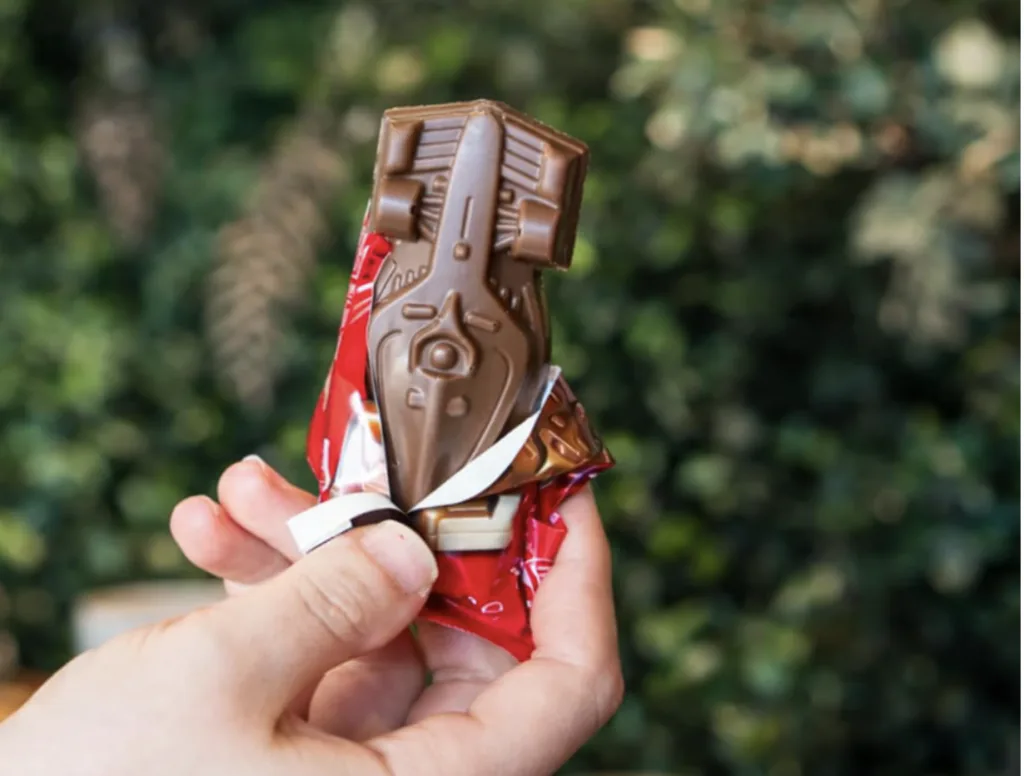 m&atilde;o segurando o chocolate kitkat em formato de carro de F1