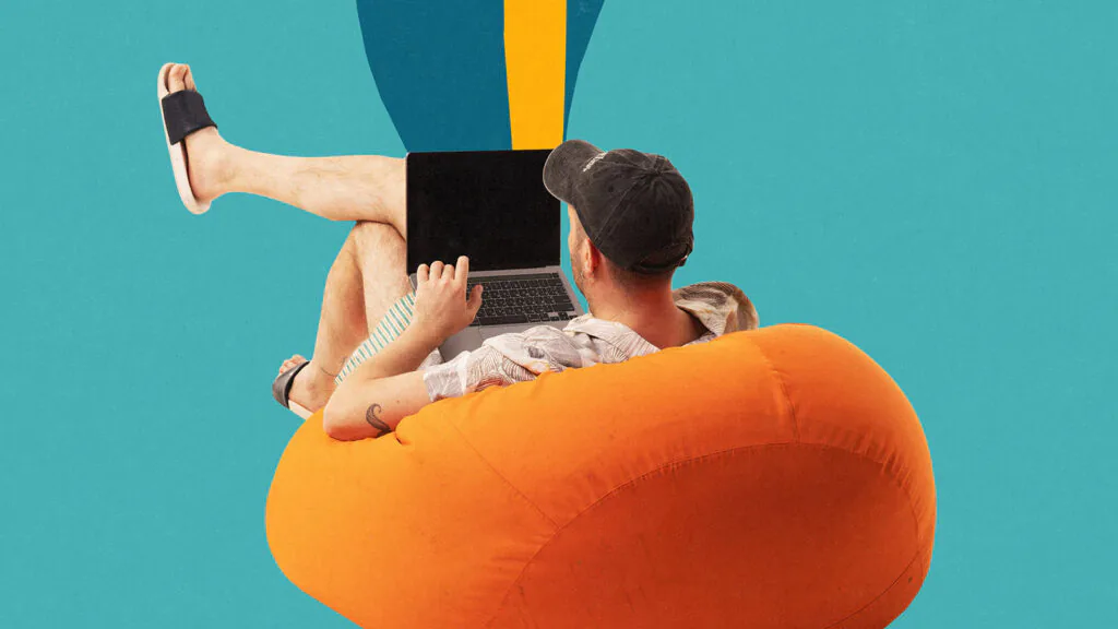A imagem mostra uma pessoa sentada de forma relaxada em um puff laranja, usando notebook no colo, com pernas esticadas e chinelos, sobre um fundo azul vibrante com formas gr&aacute;ficas. A mensagem visual remete imediatamente a trabalho remoto confort&aacute;vel, home office informal, nomadismo digital, flexibilidade profissional ou a ideia de trabalhar sem rigidez de escrit&oacute;rio. Tamb&eacute;m pode sugerir produtividade casual, cultura startup, freelancer ou gera&ccedil;&atilde;o que mistura lazer e trabalho. O contraste entre o puff macio e o laptop cria uma tens&atilde;o interessante: conforto versus performance. Dependendo do contexto, a imagem pode elogiar a liberdade de trabalhar de qualquer lugar ou criticar a romantiza&ccedil;&atilde;o de estar sempre conectado mesmo em momentos de descanso.