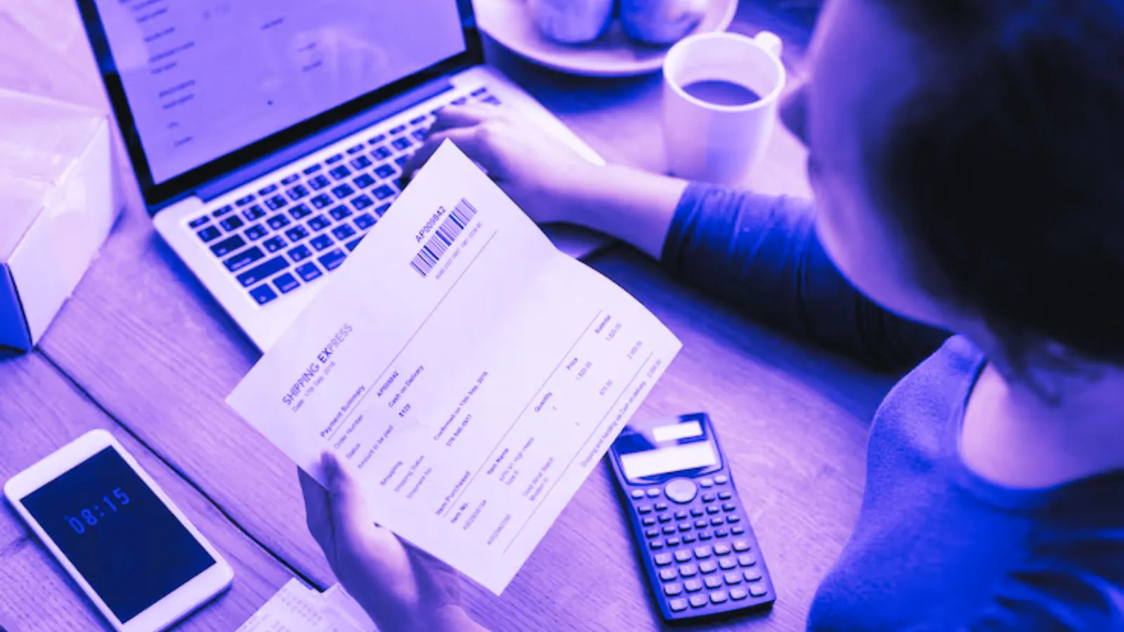 Mulher analisando documento enquanto mexe no notebook