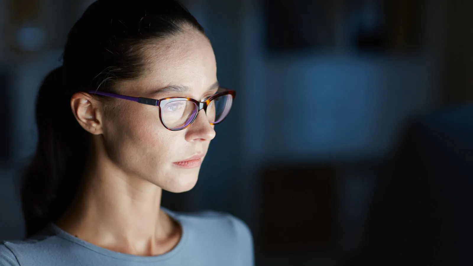 Mulher de óculos utilizando o computador