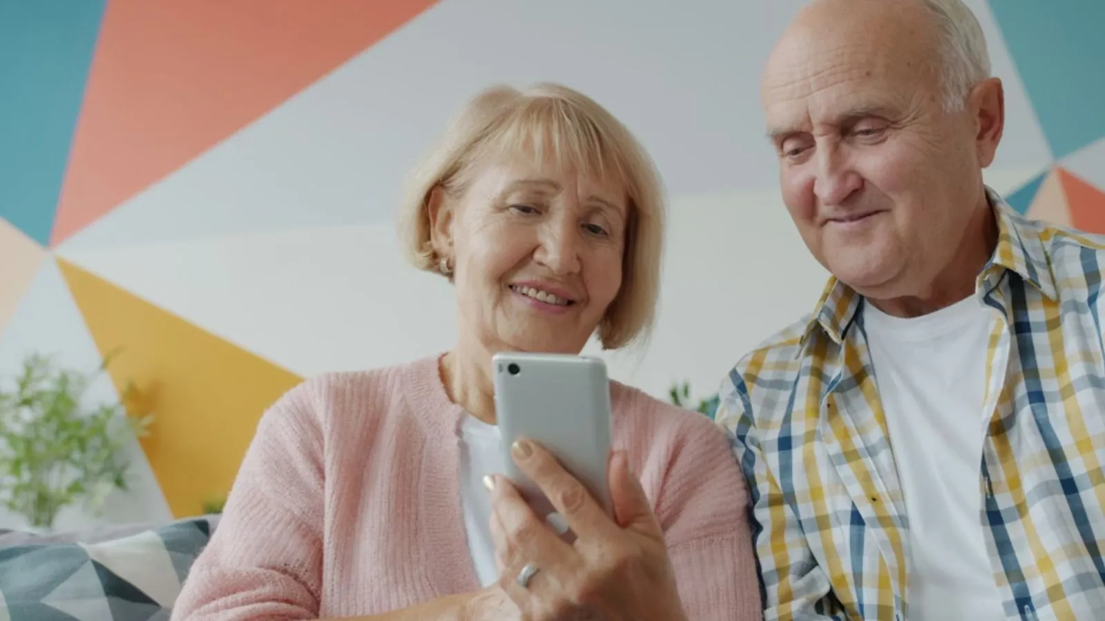 Dois idosos utilizando o celular