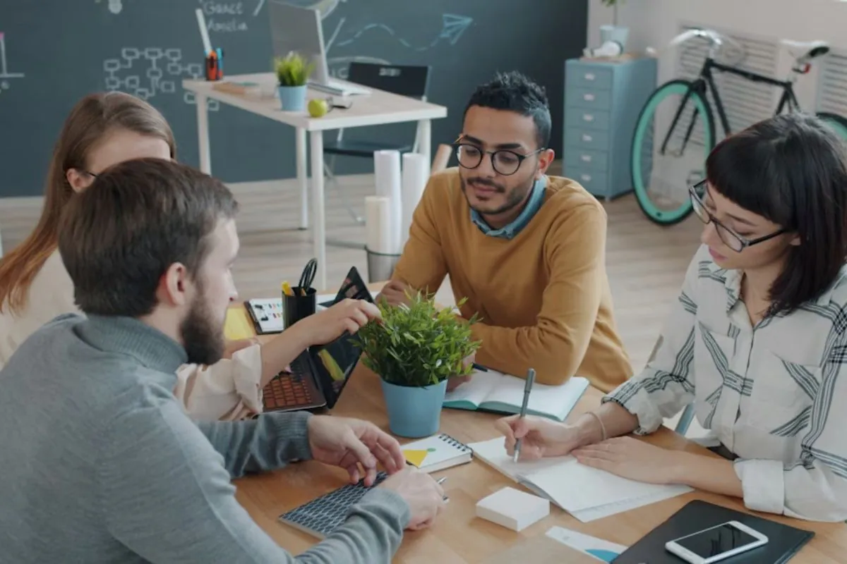 Quatro pessoas conversando em ambiente de trabalho