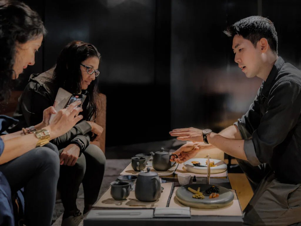Pessoas participam de uma experi&ecirc;ncia de ch&aacute; coreano em um ambiente de showroom da Genesis.