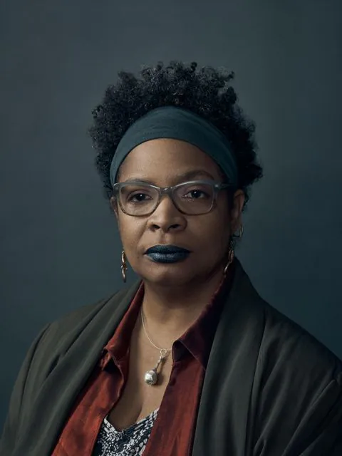 Retrato da escritora jamaicana Nalo Hopkinson, usando óculos e faixa no cabelo