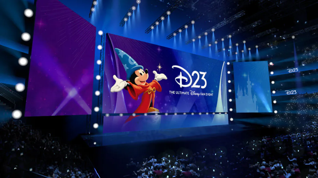 Palco do D23 no Honda Center exibe imagem do Mickey Feiticeiro diante de uma grande plateia.