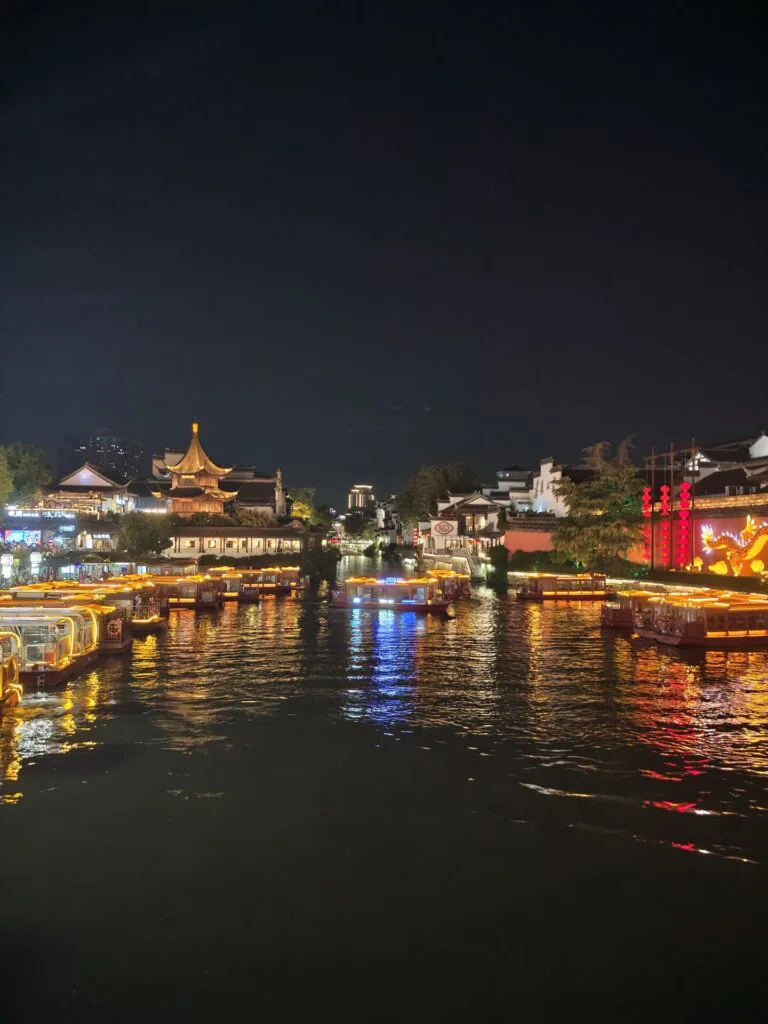 Construções tradicionais iluminadas diante dos edifícios modernos de Xangai à noite
