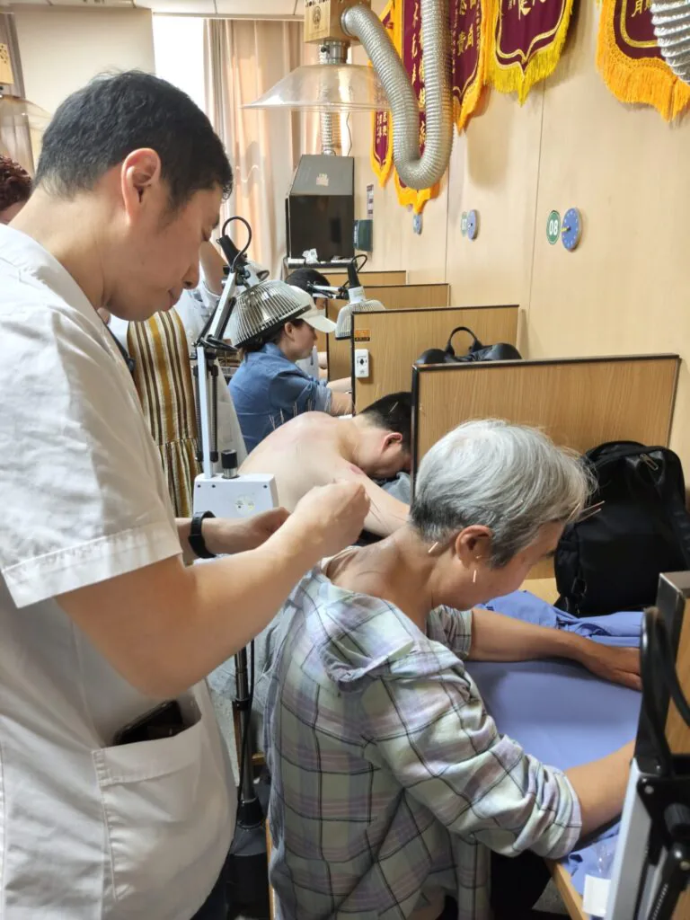Médico realiza uma sessão de acupuntura em uma paciente dentro de um hospital na China