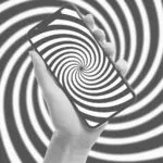 Mão segura um smartphone diante de uma espiral que representa o uso compulsivo do celular.