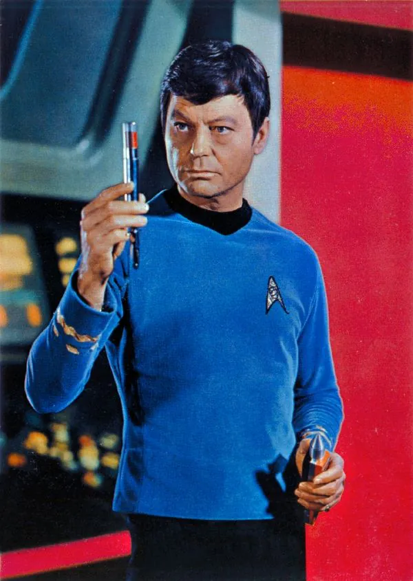 Dr. McCoy segura um aparelho m&eacute;dico port&aacute;til em cena de Star Trek